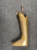 A brass companion stand in the form of a knight's armoured leg containing companion pieces