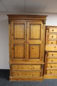 A contemporary pine double door wardrobe fitted with two drawers