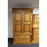 A contemporary pine double door wardrobe fitted with two drawers