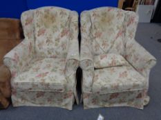 A pair of wing backed armchairs with loose floral covers