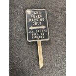 A tin Land Rover parking sign on wooden post