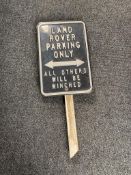 A tin Land Rover parking sign on wooden post