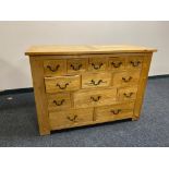 A contemporary oak thirteen drawer chest