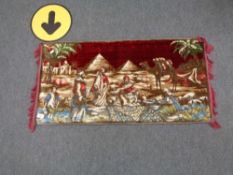 An Eastern chenille fringed tapestry depicting pyramids and camels