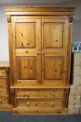 A contemporary pine double door wardrobe fitted with two drawers