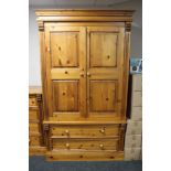 A contemporary pine double door wardrobe fitted with two drawers