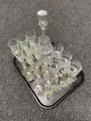 A cut glass decanter together with a tray of assorted glass