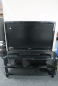 A Toshiba Regza 37" LCD TV with remote on black glass three tier stand