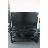 A Toshiba Regza 37" LCD TV with remote on black glass three tier stand