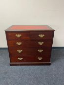 A reproduction mahogany five drawer chest with brass dropped handles and tooled leather inset panel