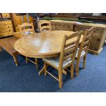 A circular pine extending table together with four ladder backed chairs