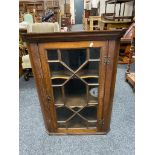 A Georgian oak hanging corner cabinet with astragal glazed door