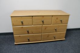 A contemporary pine seven drawer chest