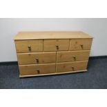 A contemporary pine seven drawer chest