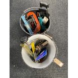 A plastic bucket and an enamel bucket containing assorted hand and power tools