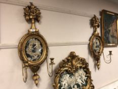 A pair of ornate gilt cherub wall sconces