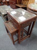 A nest of three oriental style heavily carved tables