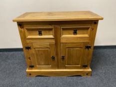A Mexican pine double door sideboard fitted with two drawers