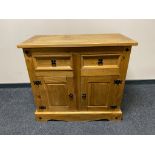A Mexican pine double door sideboard fitted with two drawers