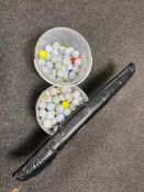 Two plastic tubs containing a large quantity of golf balls together with two piece Ronnie