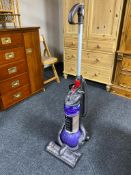 An upright vacuum together with an angle poise floor lamp and a halogen heater