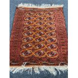 A fringed Afghan Tekke rug on orange ground