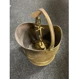 An antique brass coal bucket and companion set