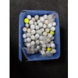 A plastic tub of golf balls