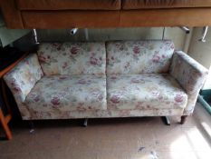 A twentieth century two seater settee in floral fabric