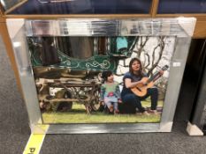 A mirrored framed picture depicting a gypsy caravan