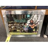 A mirrored framed picture depicting a gypsy caravan