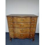 A late nineteenth century oak serpentine fronted four drawer chest on cabriole legs