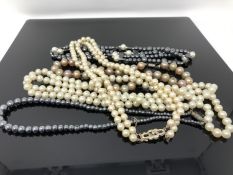A string of cultured pearls with yellow metal clasp,