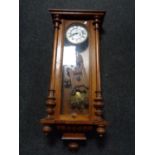 An early twentieth century mahogany cased continental wall clock with pendulum and key