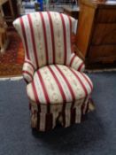 An antique nursing chair on mahogany legs in Regency striped fabric