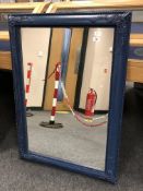A blue framed antique style mirror