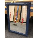 A blue framed antique style mirror