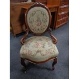 A walnut framed lady's chair upholstered in a floral tapestry fabric