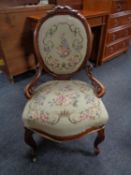A walnut framed lady's chair upholstered in a floral tapestry fabric