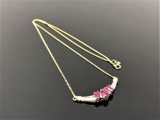 An 18ct gold diamond and ruby pendant on chain