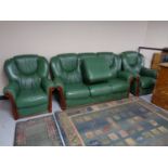 A green leather three piece lounge suite with stool