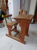 A mid twentieth century pine school desk with chair