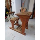 A mid twentieth century pine school desk with chair