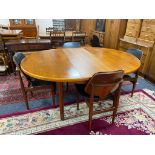 A circular teak mid century extending table and four chairs