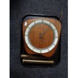 A mid century walnut wall clock with pendulum and weights