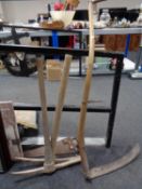 A vintage scythe together with two pick axes and hand saw