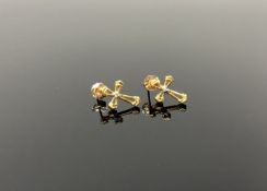 A pair of gold and diamond crucifix earrings