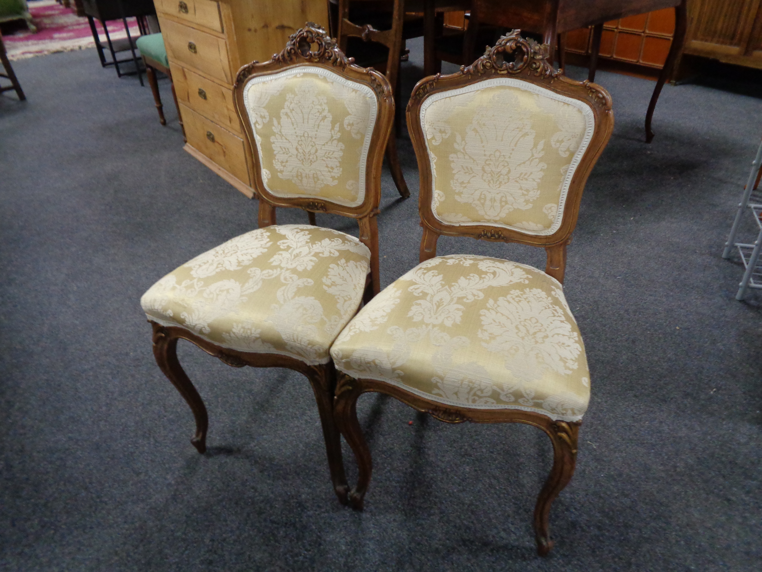 A pair of French walnut carved bedroom chairs in classical fabric