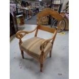 An antique pine scroll armchair