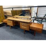 A twentieth century teak kneehole dressing table with continental headboard